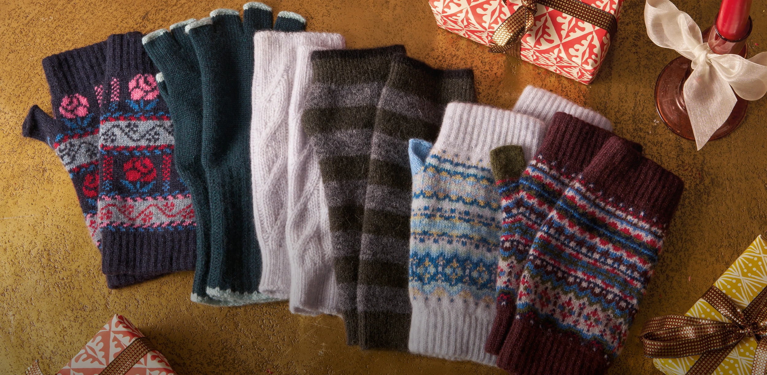 Colorful winter gloves and wrapped gifts on a festive table setting
