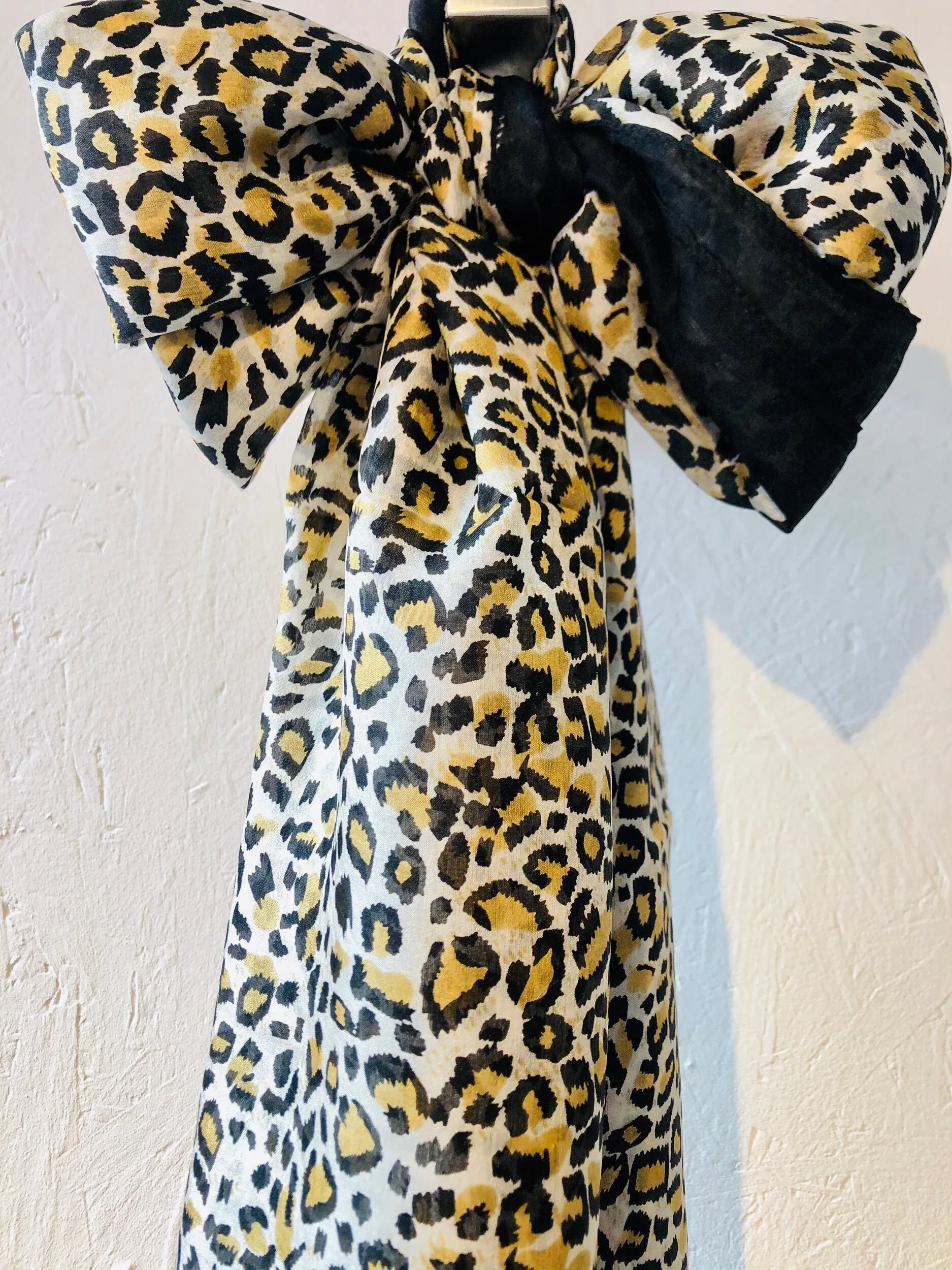 Leopard print fabric bow on a light textured background, showcasing bold and stylish design.