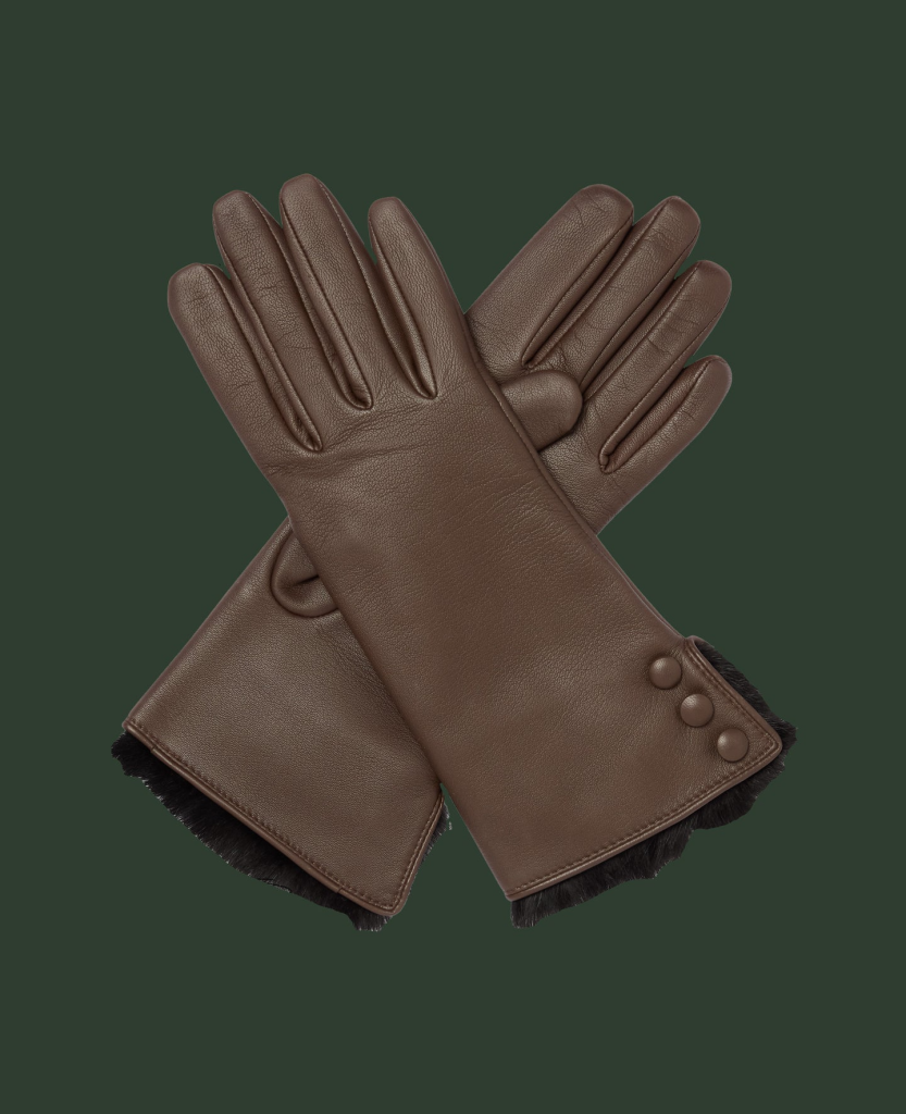 Brown leather gloves with button detail and fur trim on a dark green background.