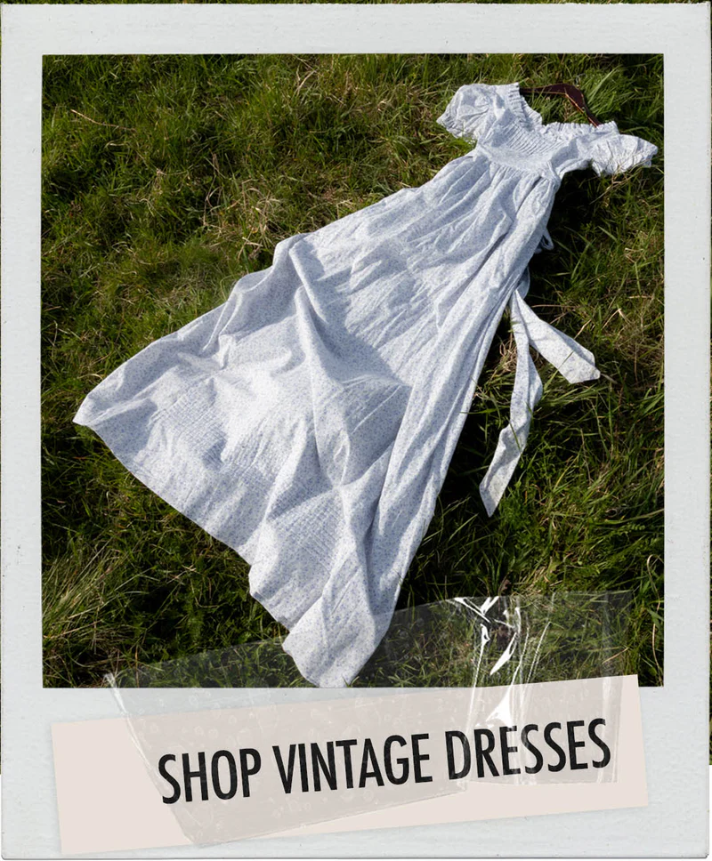 Vintage white dress on grass with text: Shop Vintage Dresses.
