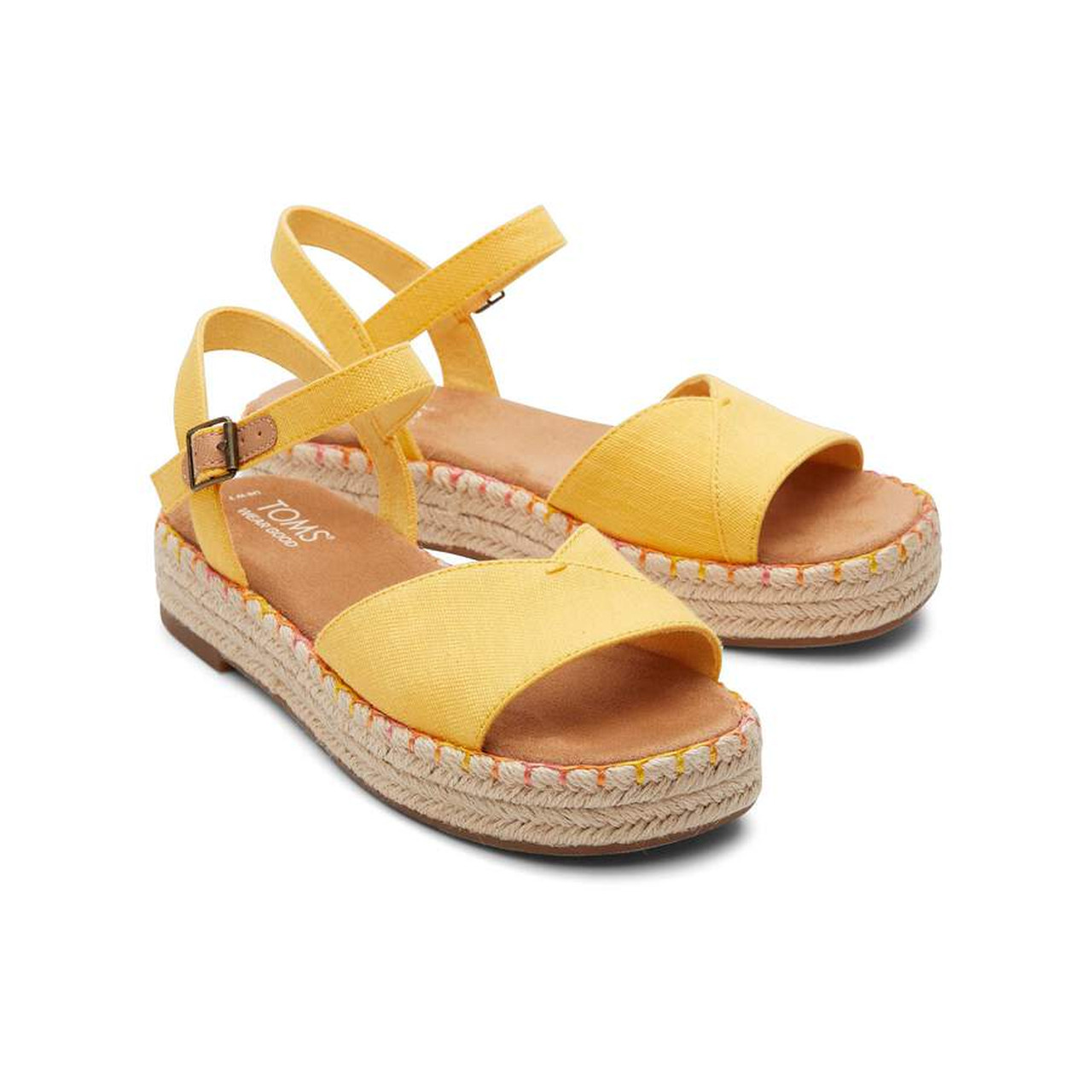 Yellow espadrille sandals with ankle straps on a white background.